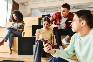 A multicultural group of students sit comfortably on a modern staircase, engaging in conversation and relaxation clipart