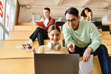 Çok kültürlü bir kadın, bir dizüstü bilgisayarın önünde oturur, online eğitim ya da iş ile ilgilenir.