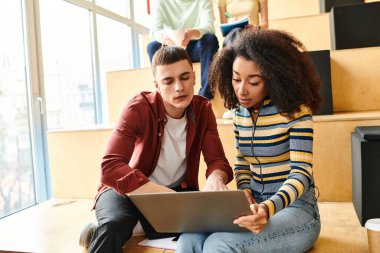 A black girl and a man sit on the floor, focused on a laptop screen, engaged in collaborative learning clipart