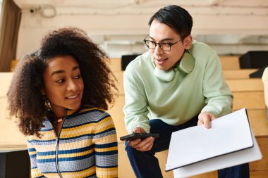 A woman and a girl, both African American, examine a piece of paper together, engrossed in what they see. clipart