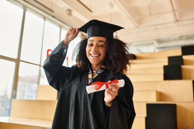 An African American woman proudly wears a graduation cap and gown, celebrating her academic achievements. clipart