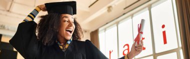 African American student proudly wears graduation cap and gown, celebrating her academic achievements, banner clipart