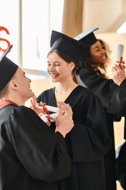 Kafkasyalı, Asyalı ve Afrikalı Amerikalı bireylerin de dahil olduğu çeşitli öğrenciler, mutlu ve birleşik bir şekilde bir çemberin içinde duruyorlar..