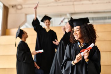 Mezuniyet elbiseleri ve havan mermileri içinde çeşitli öğrenciler akademik yolculuklarını gülümseyerek tamamlıyorlar..