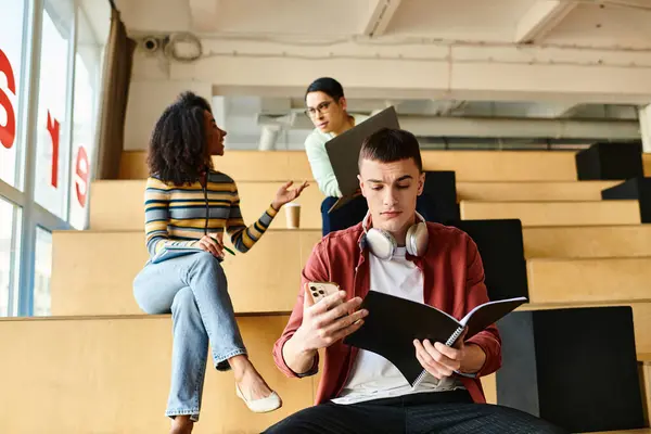 Man Engrossed Book Seated Lecture Hall Surrounded Fellow Students Diverse — Stock Photo, Image