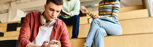A man sitting on bleachers, engrossed in his cell phone screen