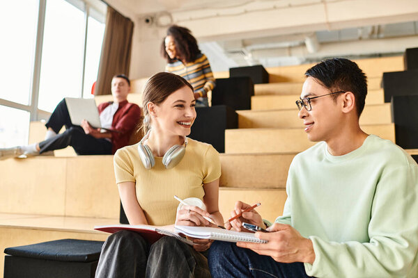 A man and woman with different ethnic backgrounds engaged in an animated conversation while seated on a chair