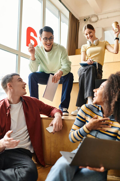 Мультикультурные студенты, включая афроамериканку, сидящую вместе, участвуют в оживленной дискуссии