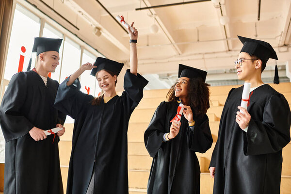 A group of students, representing various cultures, joyfully stand together in graduation gowns and academic caps.