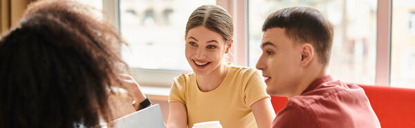 A group of students from various backgrounds sit around a table, engaged in a lively discussion.