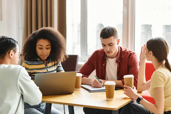 stock image A diverse group of students from various backgrounds conversing and sharing ideas around a wooden table indoors.