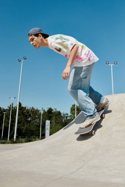 A young man glides effortlessly down the side of a ramp on his skateboard in a bustling outdoor skate park on a sunny summer day. clipart