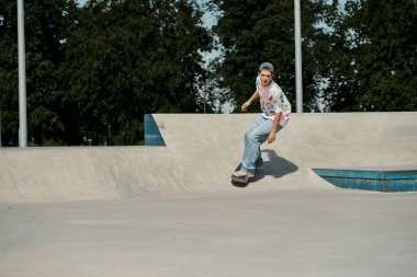 A young skater boy fearlessly rides his skateboard up the side of a ramp in a bustling outdoor skate park on a sunny summer day. clipart
