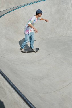 A young man recklessly rides a skateboard down a steep ramp in the summer sun at a skate park. clipart