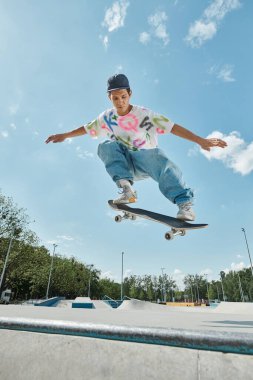 A young man confidently rides his skateboard up the steep incline of a ramp in a sunny outdoor skate park. clipart