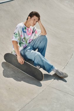 A young man embraces the thrill of skateboarding at a lively skate park on a sunny summer day. clipart
