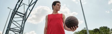A young basketball player confidently dribbles a basketball while standing outdoors on a summer day clipart