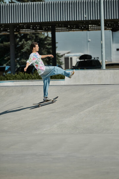 A young skater boy confidently rides a skateboard down the side of a ramp at a vibrant outdoor skate park on a sunny summer day.
