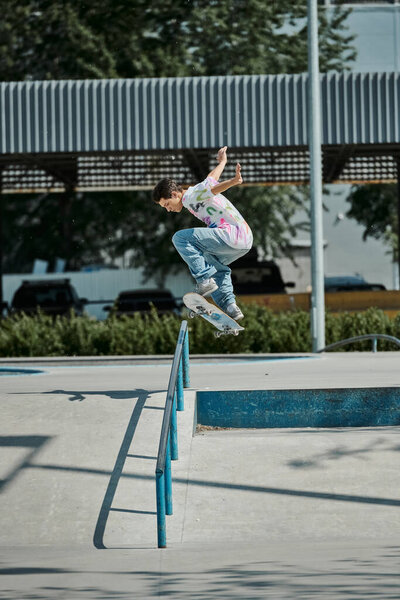 A young skater boy flies through the air on a skateboard at a skate park on a sunny summer day.
