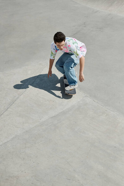 A young skater boy rides his skateboard down the side of a ramp at a skate park on a sunny summer day, feeling the adrenaline rush of the descent.