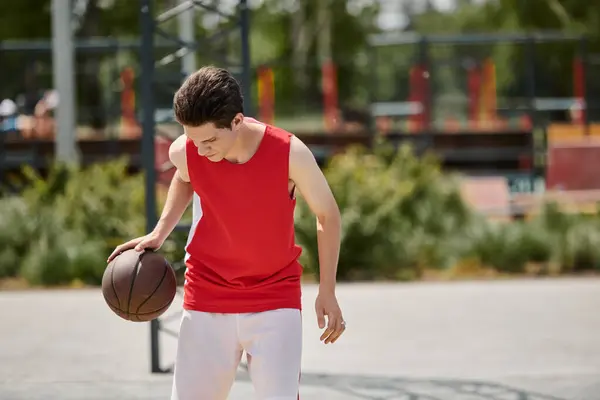 一个年轻人自信地把篮球放在生机勃勃的场地上 在比赛中流露出激情和技巧 — 图库照片