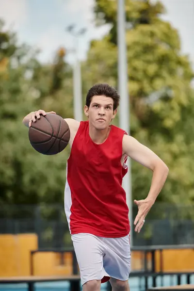 在夏日的阳光下 一个年轻人自信地把篮球放在一个充满活力的篮球场上 — 图库照片