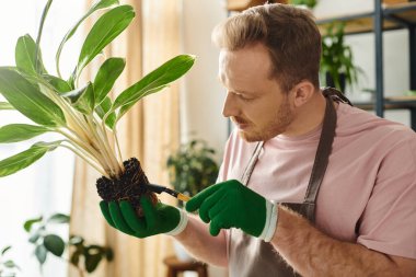 A man holds a plant gently in his hands, showcasing his love for nature and dedication to his own plant shop business. clipart