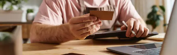 Man Sitting Desk Holding Credit Card Managing His Small Plant — Stock Photo, Image