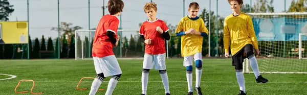A group of young men stands triumphantly on top of a lush green soccer field, basking in the glory of their victory. The players are filled with joy and camaraderie as they celebrate their teamwork and success.
