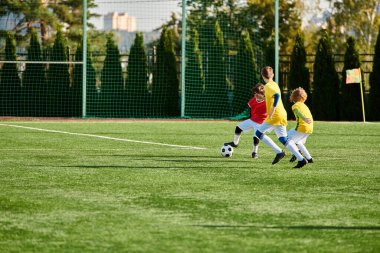 Neşeli bir grup genç çocuk futbol oynuyor, sahada koşuyor ve topa vuruyor, gülümsüyor ve rekabetçi bir ruhla..