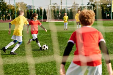 Bir grup genç adam, tutkulu bir şekilde futbol oynuyorlar. Sahada ustalıkla top sürüyorlar, pas veriyorlar ve atıyorlar, takım çalışması ve atletizm sergiliyorlar..