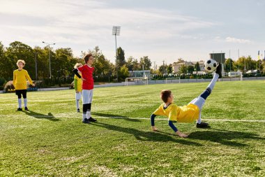 Çeşit çeşit genç bireyler yemyeşil bir alanda yoğun bir futbol oyunu oynuyorlar. Top sürüyorlar, pas veriyorlar ve atıyorlar. Yeteneklerini ve takım çalışmalarını sergiliyorlar..