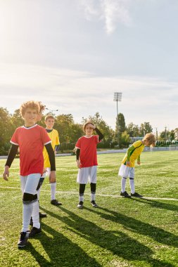 Bir grup hevesli genç erkek bir futbol sahasının tepesinde gururla duruyor, gelecekteki zaferleri ve sporda başarı hayalleri kurarken özgüven ve kararlılık yayıyorlar..
