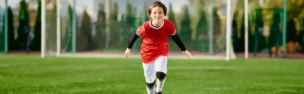 A young girl, dressed in a soccer uniform, sprints across the grassy field with determination and speed, showcasing her passion for the sport.