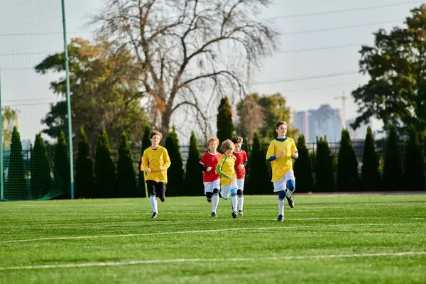 A group of young boys energetically playing a game of soccer on a grassy field, kicking the ball back and forth while laughing and cheering each other on.
