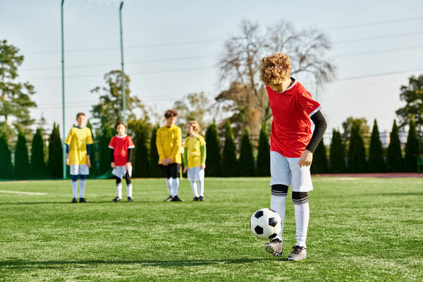 Группа молодых людей гордо стоит на футбольном поле, их силуэты освещены заходящим солнцем, когда они празднуют свою победу.