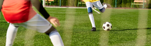 Мальчик, полный энергии, умело пинает футбольный мяч по зеленому полю. Он полностью контролирует мяч, демонстрируя отличную технику и сосредоточенность на тренировках..