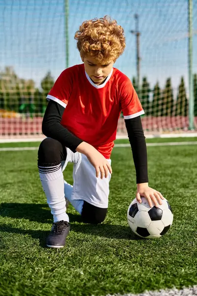 Young Boy Dark Hair Kneels Grass Reaching Out Pick Soccer — Stock Photo, Image