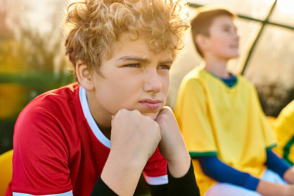 Два молодых человека сидят близко друг к другу, погруженные в беседу. Их выражения созерцательны, воплощают в себе чувство связи и взаимопонимания между ними.