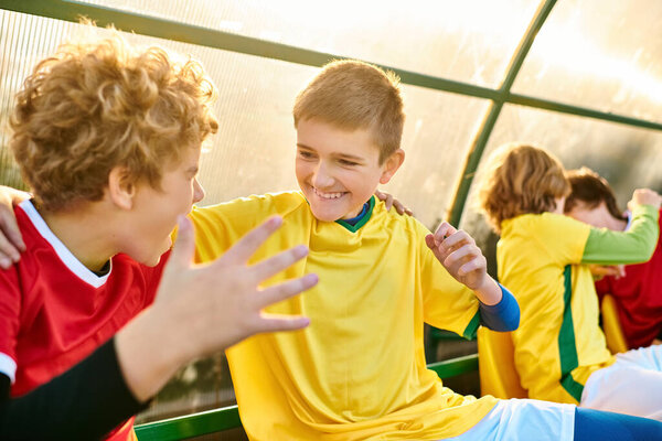 Группа разноплановых молодых людей сидит вместе, разговаривая и смеясь. Они кажутся связанными и поддерживающими, демонстрируя красоту camaraderie.