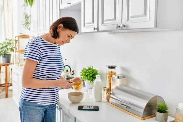 キッチンで食べ物を準備する居心地の良いホームウェアの女性 — ストック写真