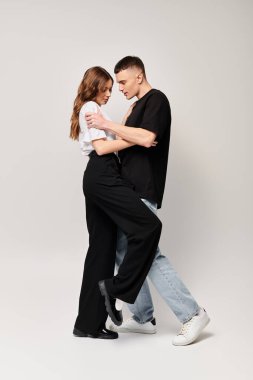 A man and woman gracefully sway together in an intimate dance, showcasing their love and connection. clipart