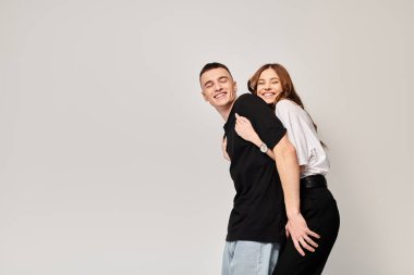 Bir erkek ve kadın, genç bir çift, gri bir geçmişle bir stüdyoda birbirlerine sevgiyle sarılıyorlar..