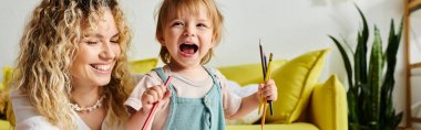 Kıvırcık saçlı bir anne ve küçük kızı Montessori eğitim yöntemini takip ediyorlar..