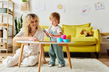 A curly mother and her toddler daughter sit at a table, engaging in Montessori learning activities together at home. clipart