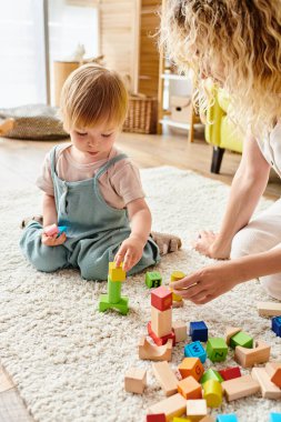 Kıvırcık saçlı anne, evde Montessori eğitim yöntemini kullanarak küçük kızıyla sevgi dolu bir ilişki kuruyor..