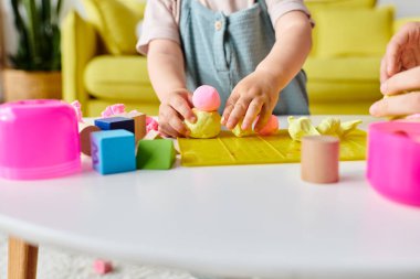 Bir anne küçük kızına renkli bloklar ve şekillerle Montessori 'de rehberlik eder..
