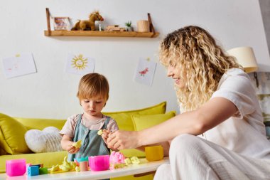 Kıvırcık bir anne ve küçük kızı evde Montessori eğitim yöntemini kullanarak eğlenceli bir öğrenim görürler..
