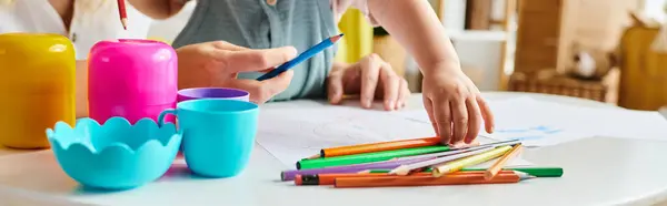 Woman Sits Table Focused Bunch Crayons Her Toddler Daughter Embracing — Stok fotoğraf