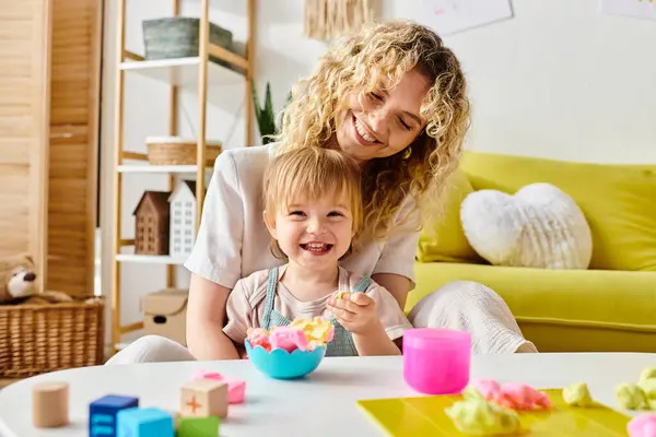 stock image A curly mother and her toddler daughter engage in Montessori learning at a cozy table, exploring new discoveries.